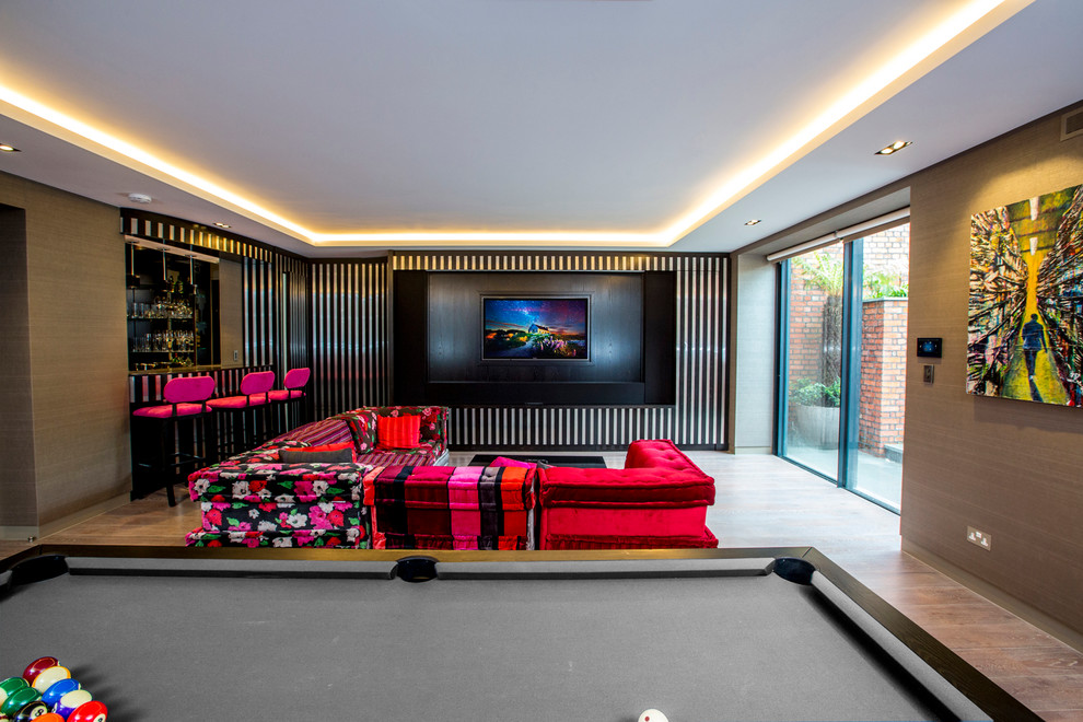 Imagen de sala de estar abierta contemporánea de tamaño medio con paredes beige y suelo de madera clara