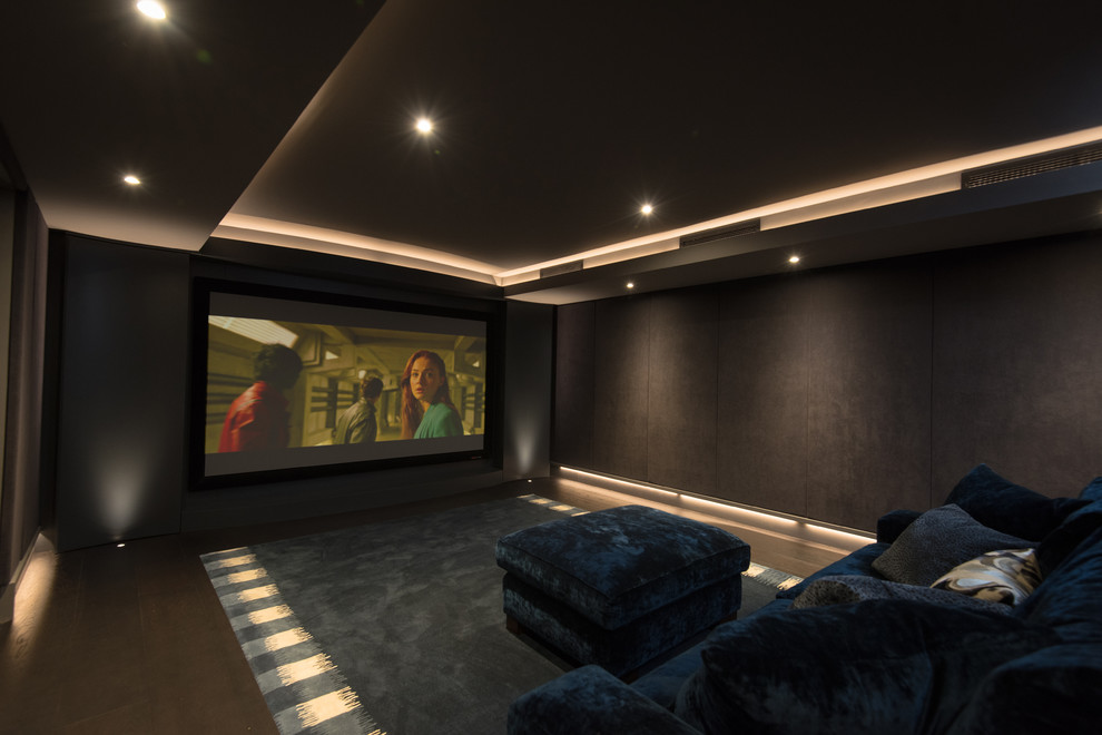 Idee per un home theatre minimal di medie dimensioni e chiuso con pareti nere, schermo di proiezione e pavimento blu
