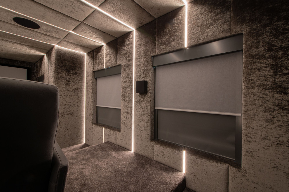 Idées déco pour une salle de cinéma moderne de taille moyenne et fermée avec un mur gris, moquette, un écran de projection et un sol gris.