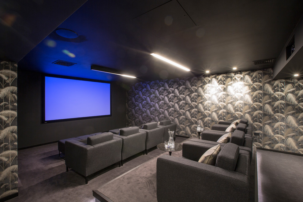 На фото: изолированный домашний кинотеатр среднего размера в современном стиле с серыми стенами, проектором, серым полом и ковровым покрытием с