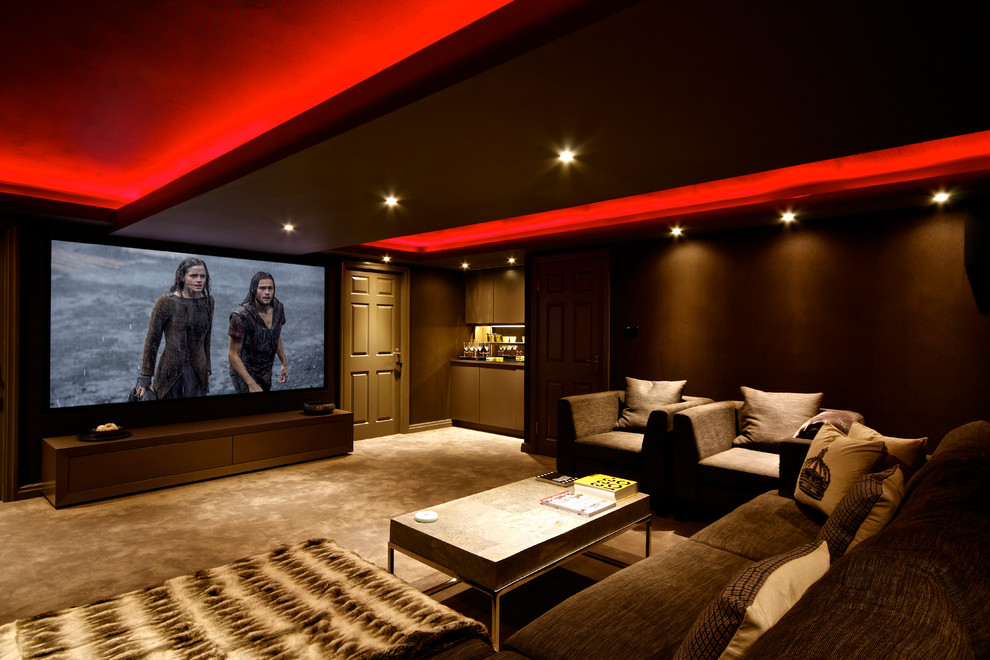 Стильный дизайн: большой изолированный домашний кинотеатр в современном стиле с коричневыми стенами, ковровым покрытием и проектором - последний тренд