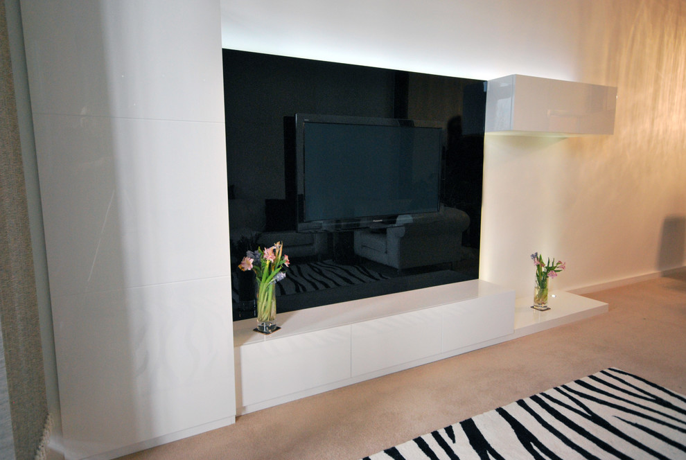 Foto de cine en casa abierto actual de tamaño medio con paredes blancas, suelo de madera clara y televisor colgado en la pared