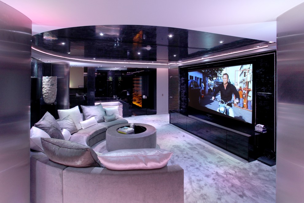 This is an example of a large modern open plan home cinema in Cheshire with black walls and carpet.