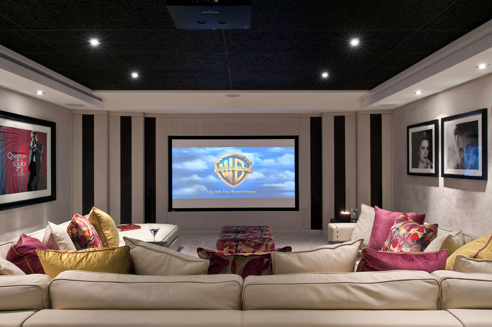Imagen de cine en casa cerrado actual de tamaño medio con pantalla de proyección, moqueta y paredes grises