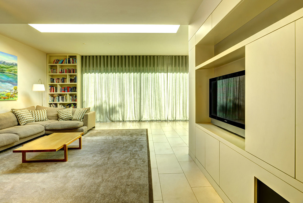 Inspiration for a large modern open plan home cinema in London with beige walls, ceramic flooring and a built-in media unit.