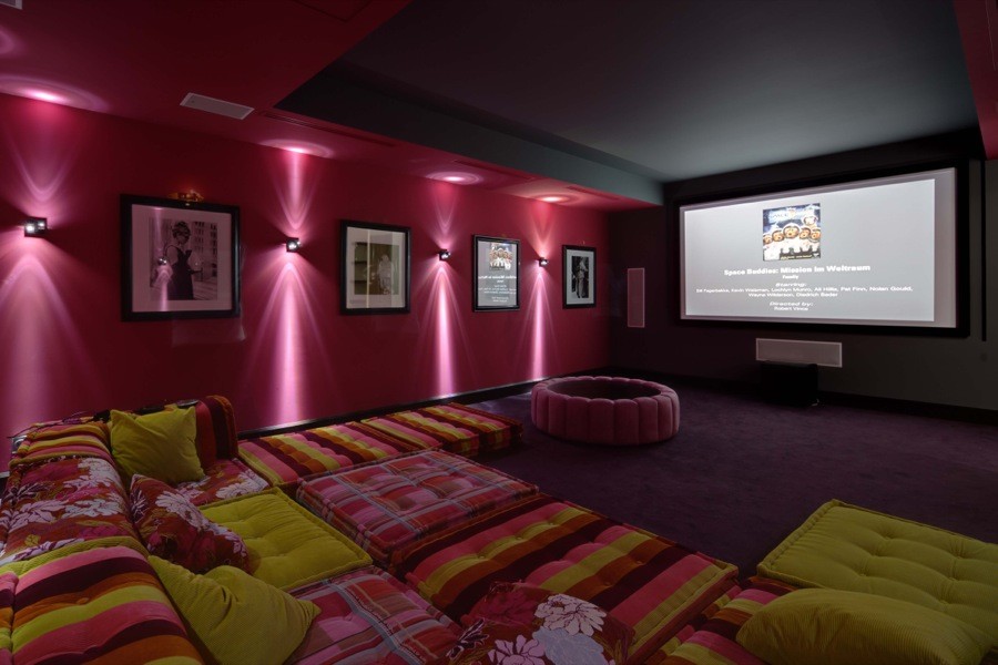 На фото: большой изолированный домашний кинотеатр в современном стиле с розовыми стенами, ковровым покрытием, проектором и фиолетовым полом