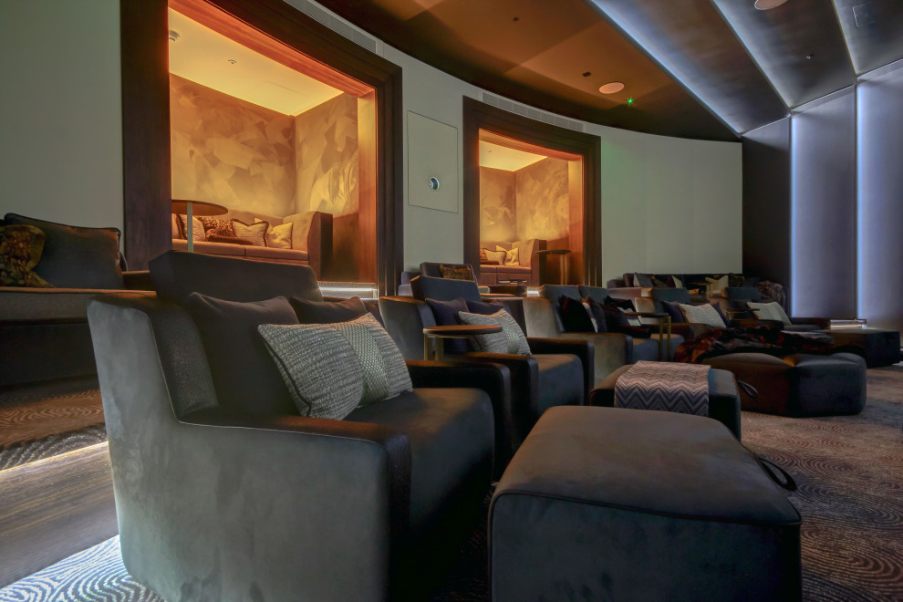 Inspiration for a large modern enclosed carpeted and gray floor home theater remodel in Surrey with gray walls and a projector screen