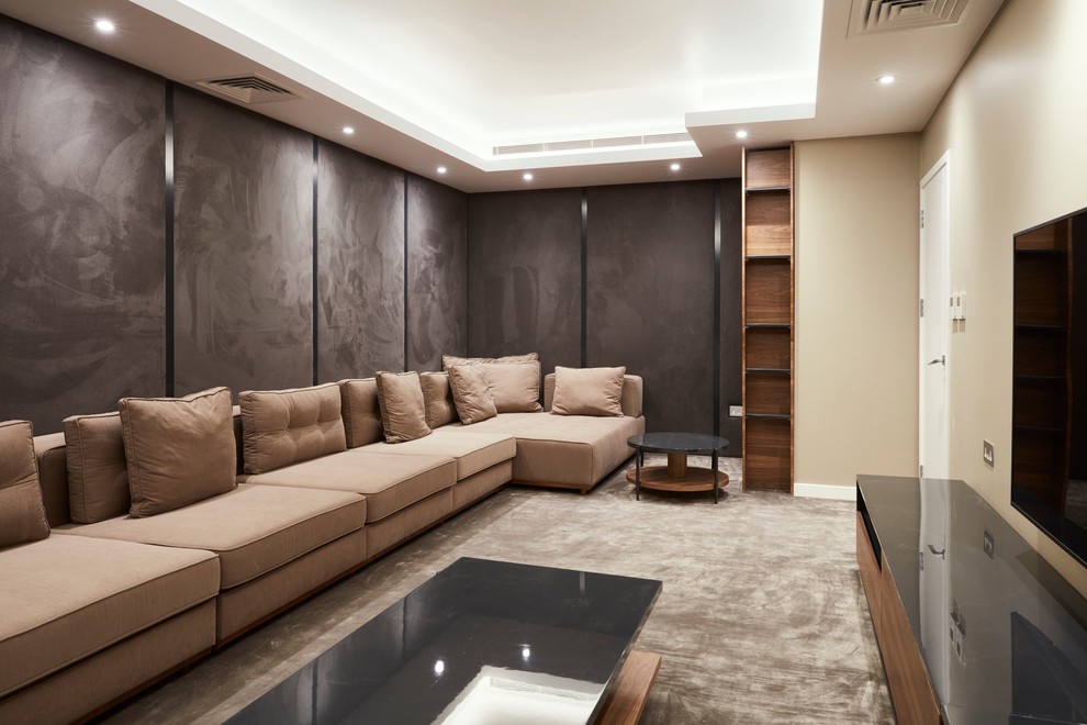 Bild på ett stort funkis avskild hemmabio, med beige väggar, heltäckningsmatta, en väggmonterad TV och grått golv