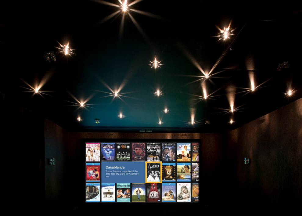 Photo of a medium sized modern enclosed home cinema in London with a projector screen.