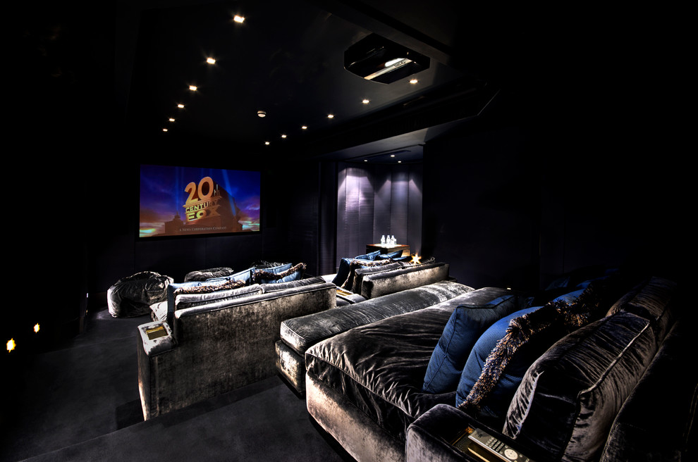 Ejemplo de cine en casa cerrado clásico grande con paredes negras, moqueta, suelo negro y pantalla de proyección