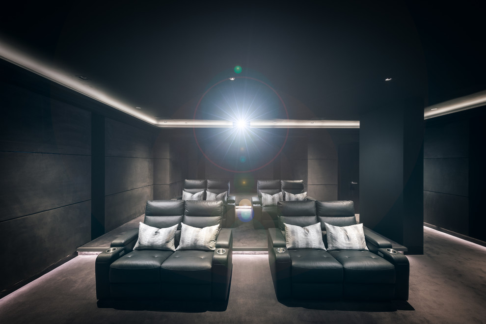 Foto de cine en casa cerrado moderno grande con paredes negras, moqueta y televisor colgado en la pared