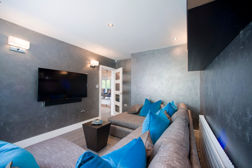 Diseño de cine en casa cerrado contemporáneo de tamaño medio con paredes grises y televisor colgado en la pared