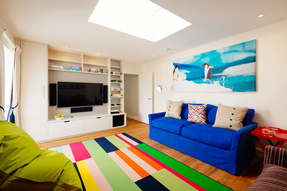 Inspiration for a mid-sized coastal gender-neutral medium tone wood floor playroom remodel in Cornwall with white walls