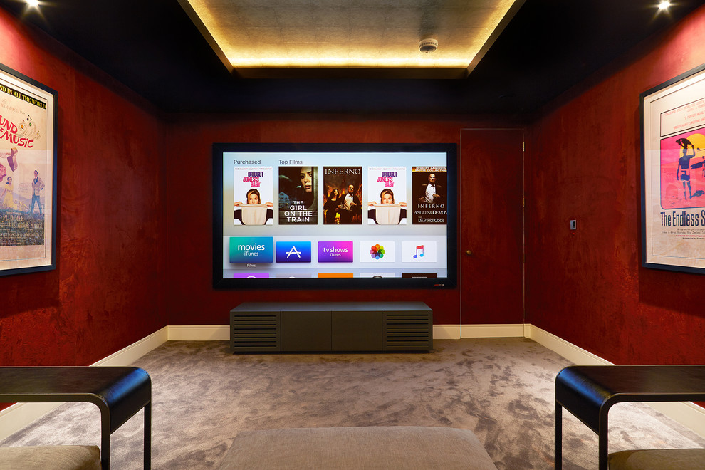 Medium sized contemporary enclosed home cinema in London with red walls, carpet, a projector screen and beige floors.