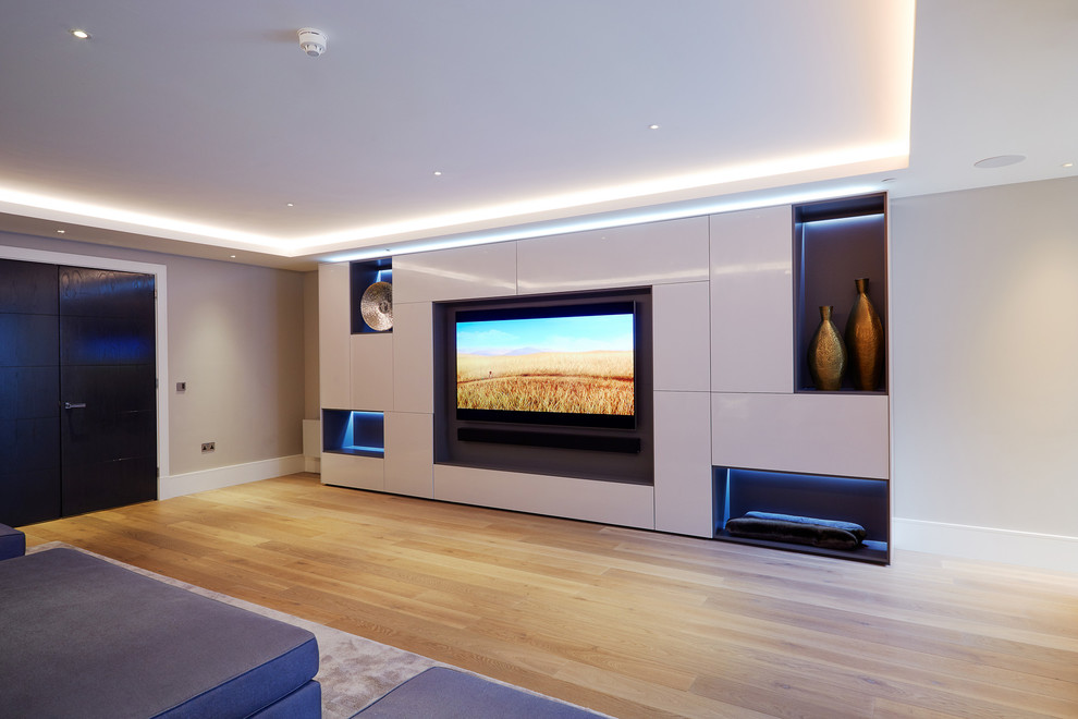 Idéer för ett stort modernt avskild hemmabio, med beige väggar, ljust trägolv, en väggmonterad TV och beiget golv