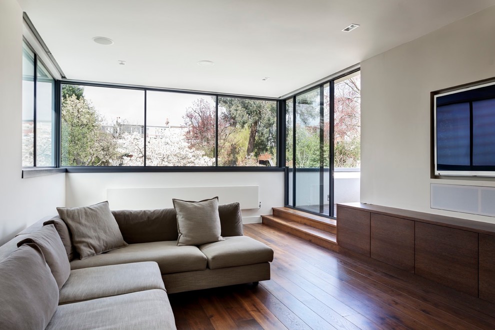 Großes, Offenes Modernes Heimkino mit weißer Wandfarbe, dunklem Holzboden, TV-Wand und braunem Boden in London