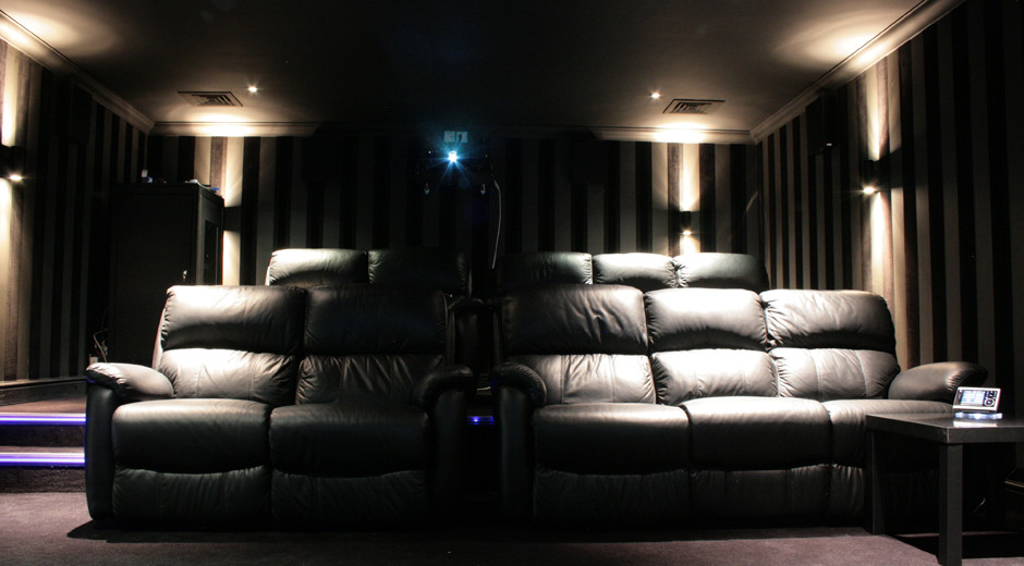 Источник вдохновения для домашнего уюта: большой изолированный домашний кинотеатр в современном стиле с коричневыми стенами, ковровым покрытием и телевизором на стене