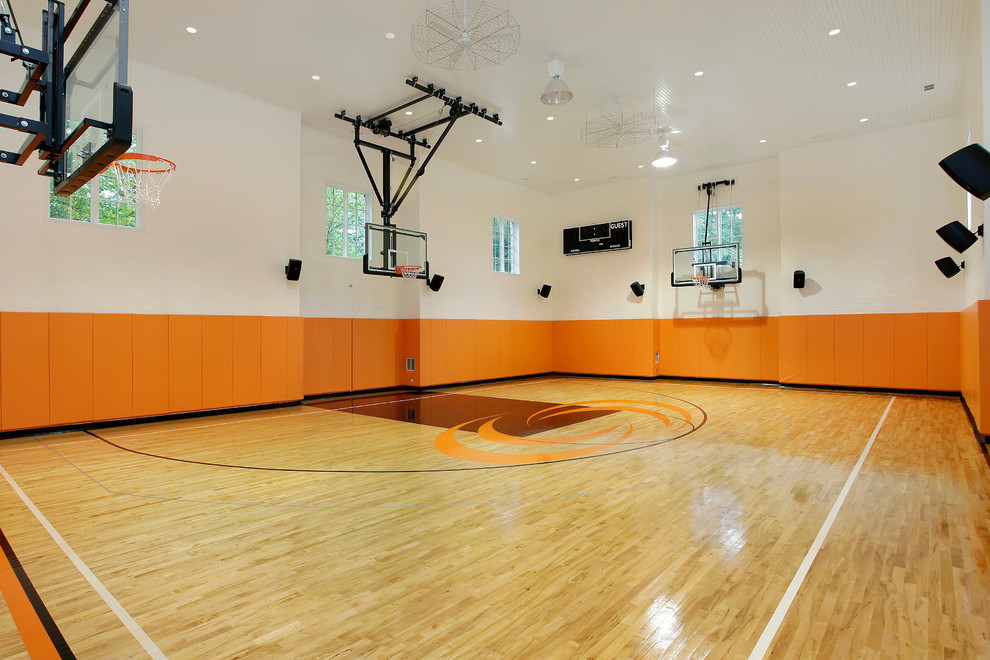 Aménagement d'un grand terrain de sport intérieur classique avec un mur multicolore, parquet clair et un sol marron.