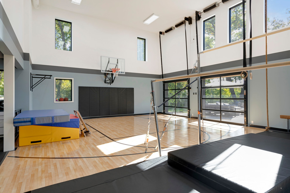 Großer Moderner Fitnessraum mit Indoor-Sportplatz, bunten Wänden, hellem Holzboden und braunem Boden in Minneapolis