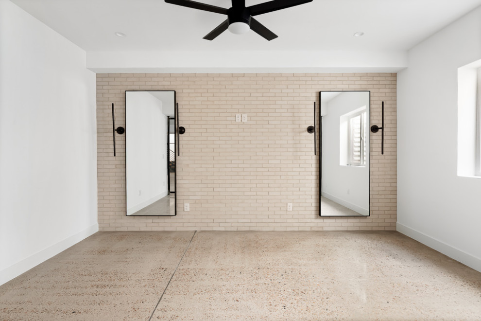 This is an example of an industrial multi-use home gym in Denver with white walls, concrete flooring and grey floors.