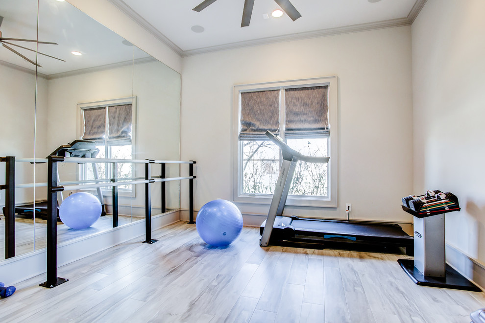 Example of a mid-sized transitional laminate floor and brown floor home gym design in Austin with beige walls