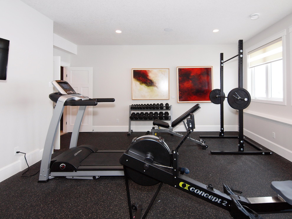 This is an example of a traditional multi-use home gym in Edmonton with white walls and black floors.