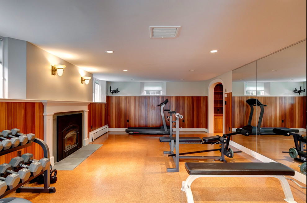 This is an example of a large classic home weight room in Boston with white walls and cork flooring.