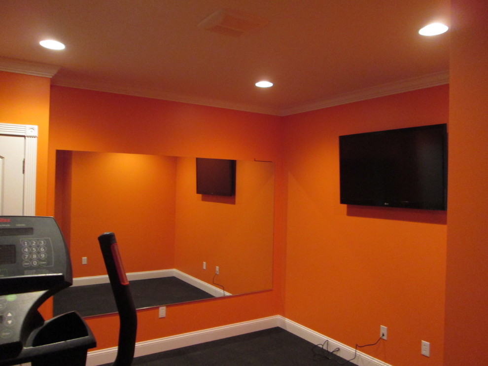 Свежая идея для дизайна: домашний тренажерный зал в стиле неоклассика (современная классика) с тренажерами, оранжевыми стенами и ковровым покрытием - отличное фото интерьера