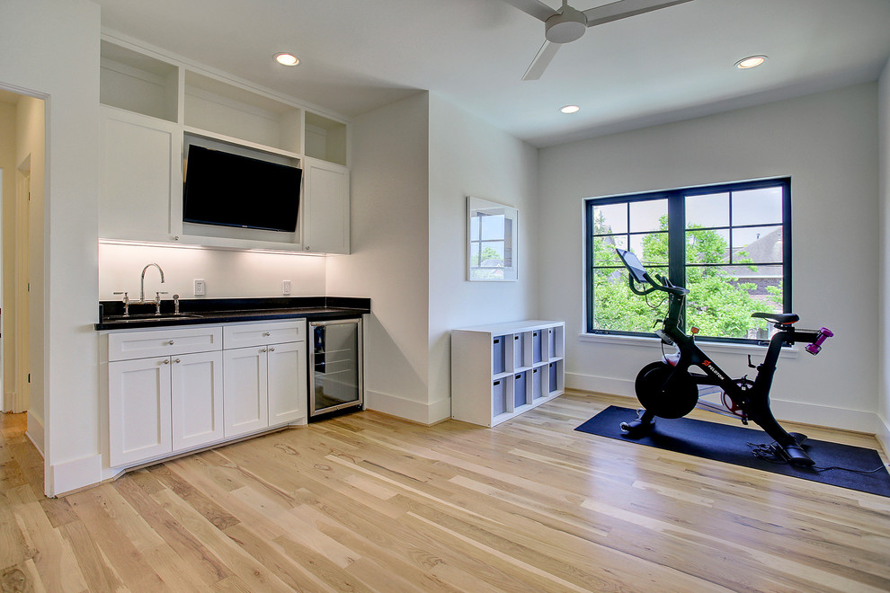 Multifunktionaler, Mittelgroßer Moderner Fitnessraum mit weißer Wandfarbe, hellem Holzboden und braunem Boden in Houston