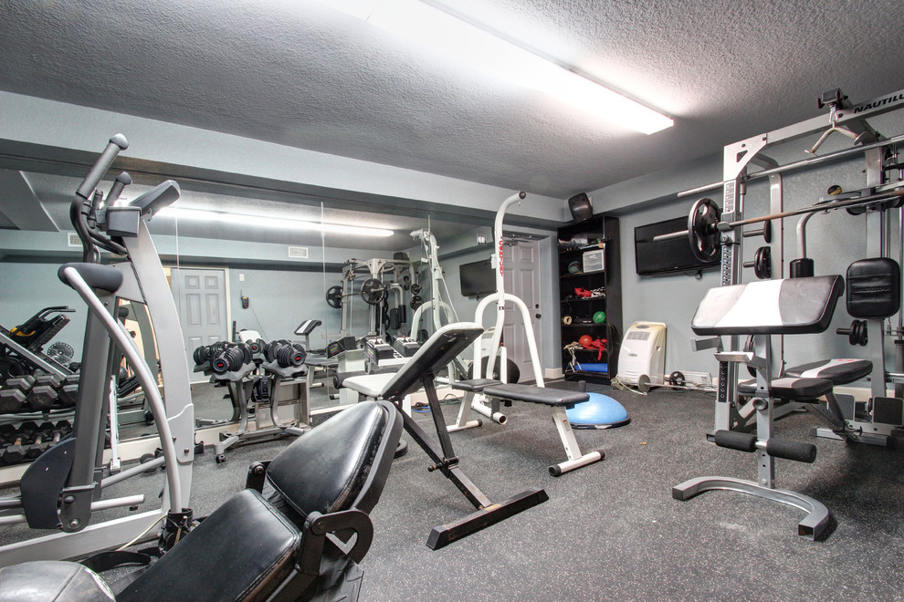 Photo of a large traditional home weight room in Tampa with grey walls.