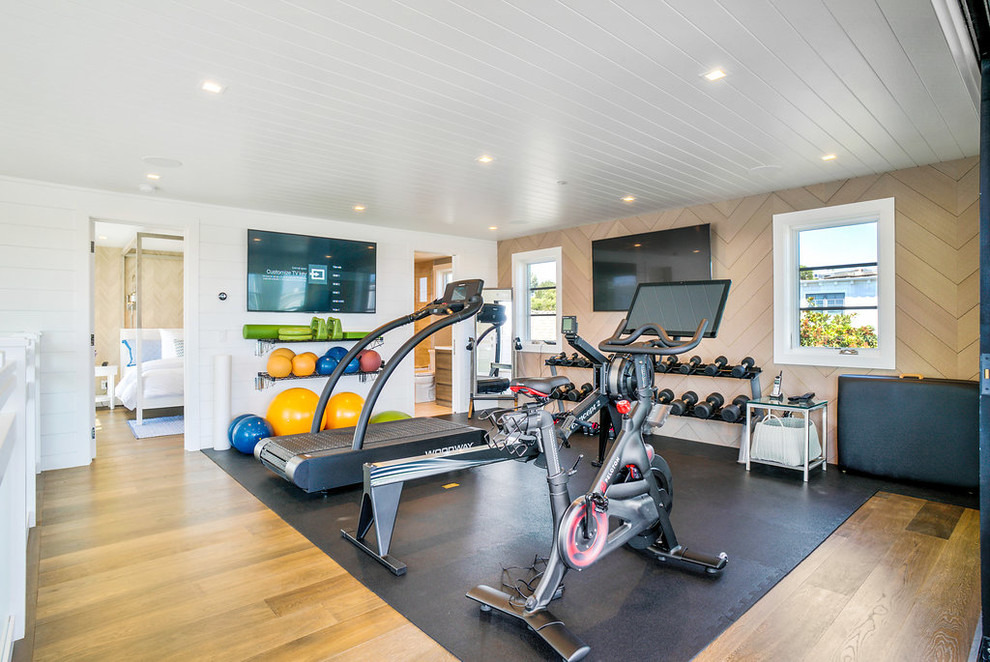 Large transitional medium tone wood floor and brown floor multiuse home gym photo in Los Angeles with beige walls