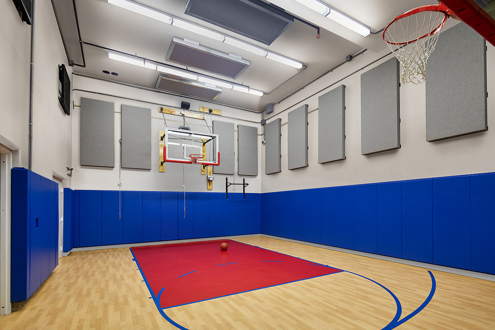 Klassischer Fitnessraum mit Indoor-Sportplatz, blauer Wandfarbe und gebeiztem Holzboden in Washington, D.C.