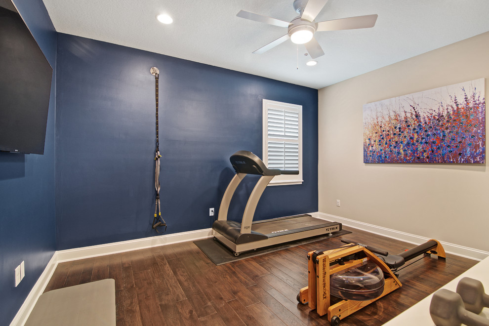 Idée de décoration pour une salle de sport tradition multi-usage avec un mur bleu et un sol en bois brun.