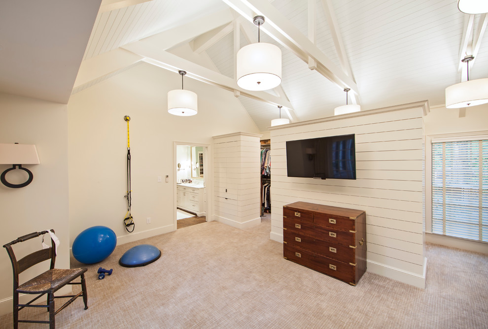 This is an example of a traditional multi-use home gym in Charlotte with white walls, carpet, beige floors and feature lighting.