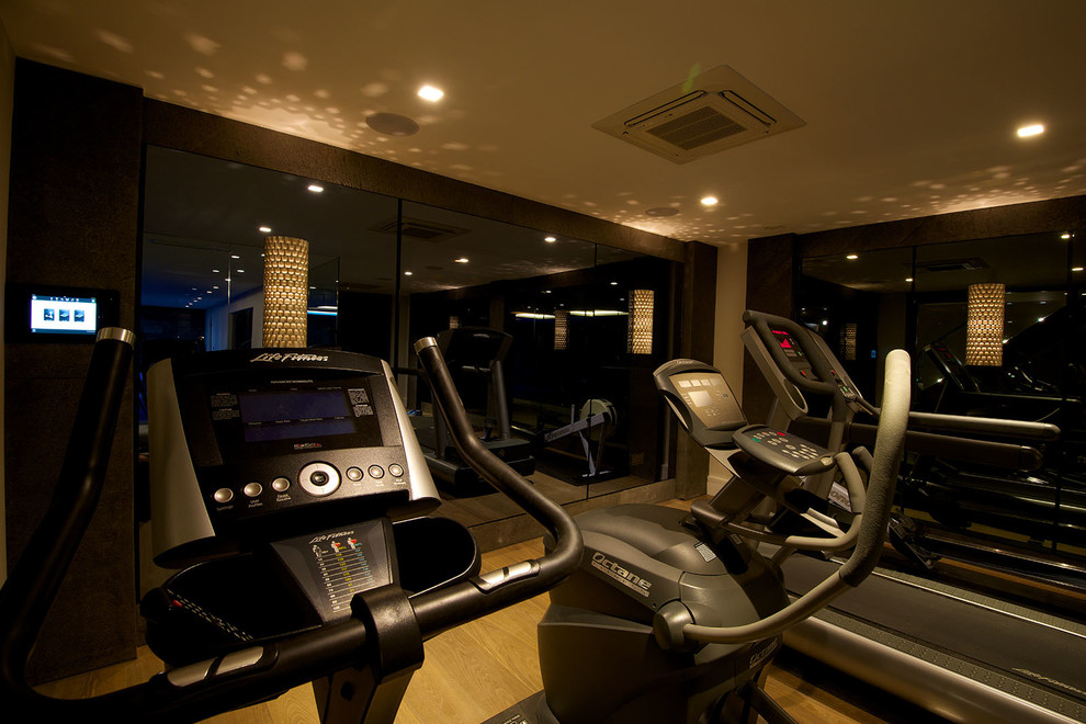 This is an example of a contemporary home gym in Cheshire with medium hardwood flooring.