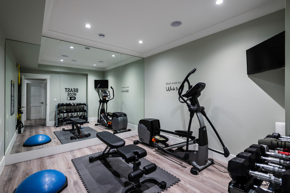 Foto de sala de pesas clásica de tamaño medio con paredes grises, suelo de baldosas de porcelana y suelo gris