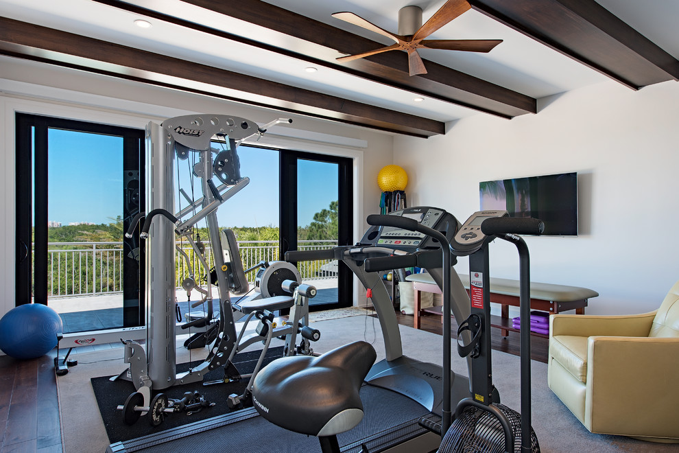 Modelo de gimnasio multiusos, tradicional renovado, con paredes blancas, suelo de madera oscura y suelo marrón