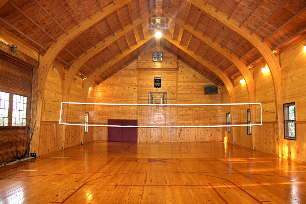Geräumiger Country Fitnessraum mit Indoor-Sportplatz, brauner Wandfarbe, braunem Holzboden und braunem Boden in Sonstige