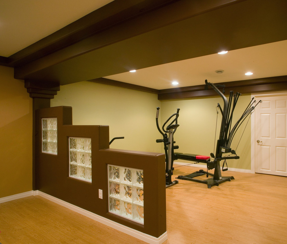 Großer Moderner Fitnessraum mit beiger Wandfarbe und hellem Holzboden in Sonstige