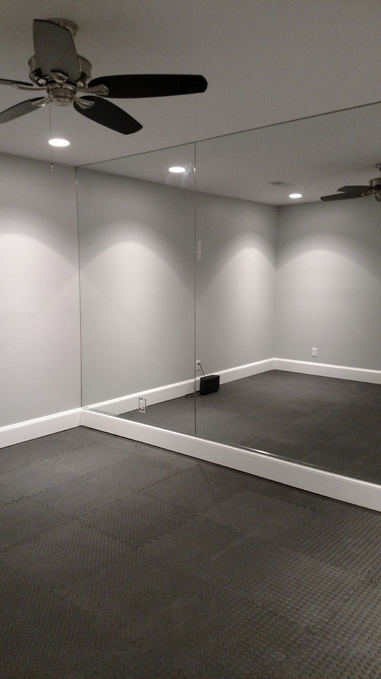 Foto de sala de pesas tradicional grande con paredes grises