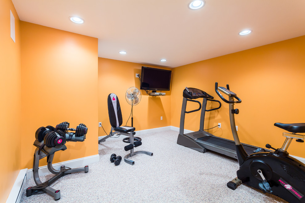 Exemple d'une salle de musculation chic de taille moyenne avec un mur orange et moquette.