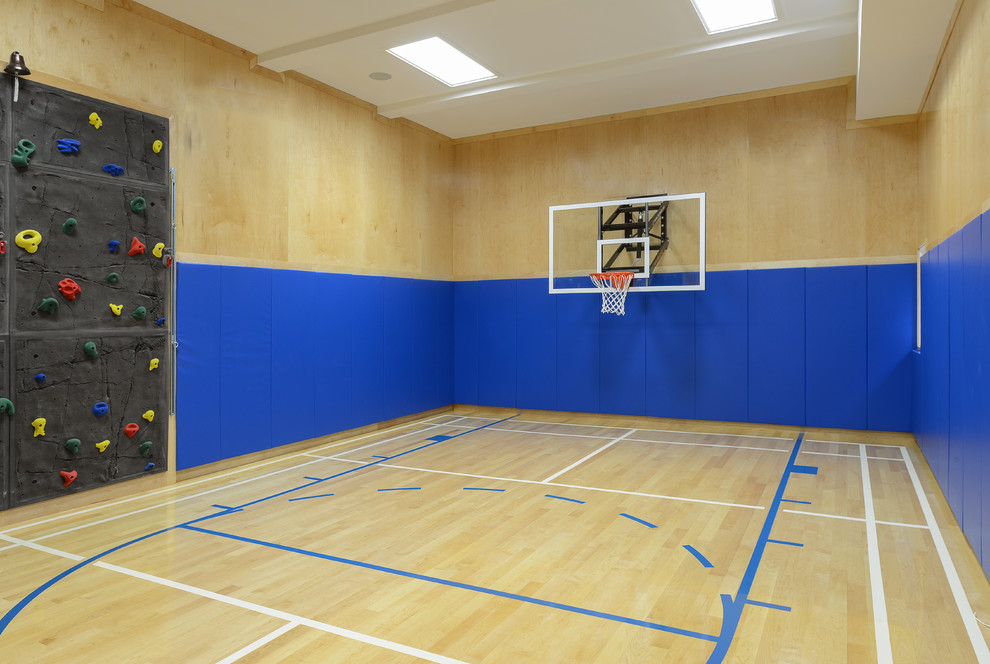 Geräumiger Moderner Fitnessraum mit Indoor-Sportplatz, blauer Wandfarbe und hellem Holzboden in New York