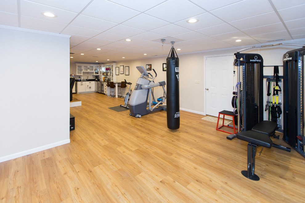 Großer, Multifunktionaler Moderner Fitnessraum mit beiger Wandfarbe, hellem Holzboden und gelbem Boden in New York