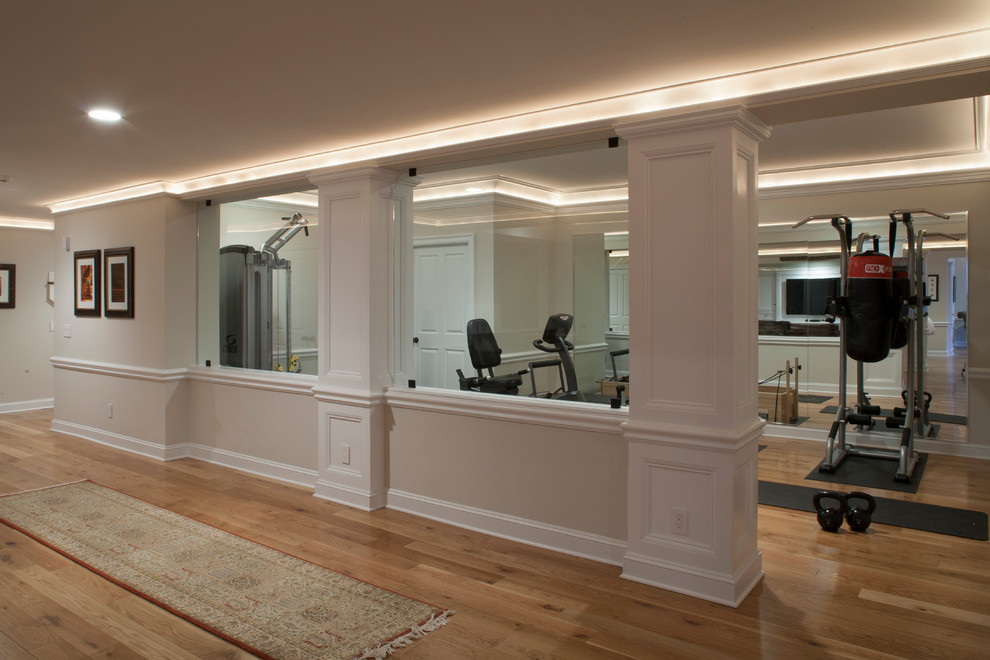 Multifunktionaler, Großer Klassischer Fitnessraum mit beiger Wandfarbe und braunem Holzboden in New York