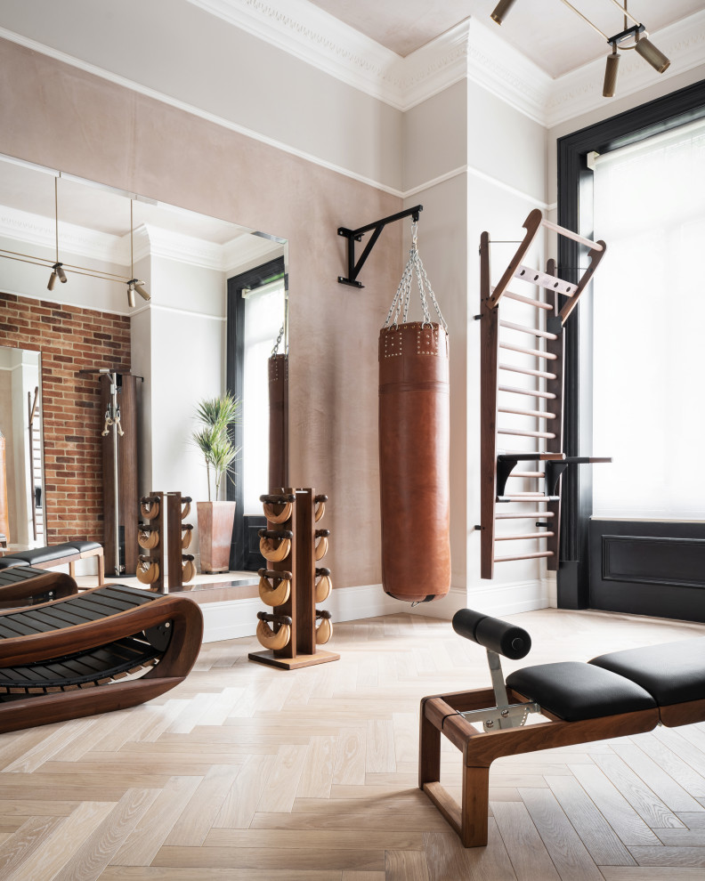 Photo of a classic home gym in London with grey walls, medium hardwood flooring, brown floors and a feature wall.
