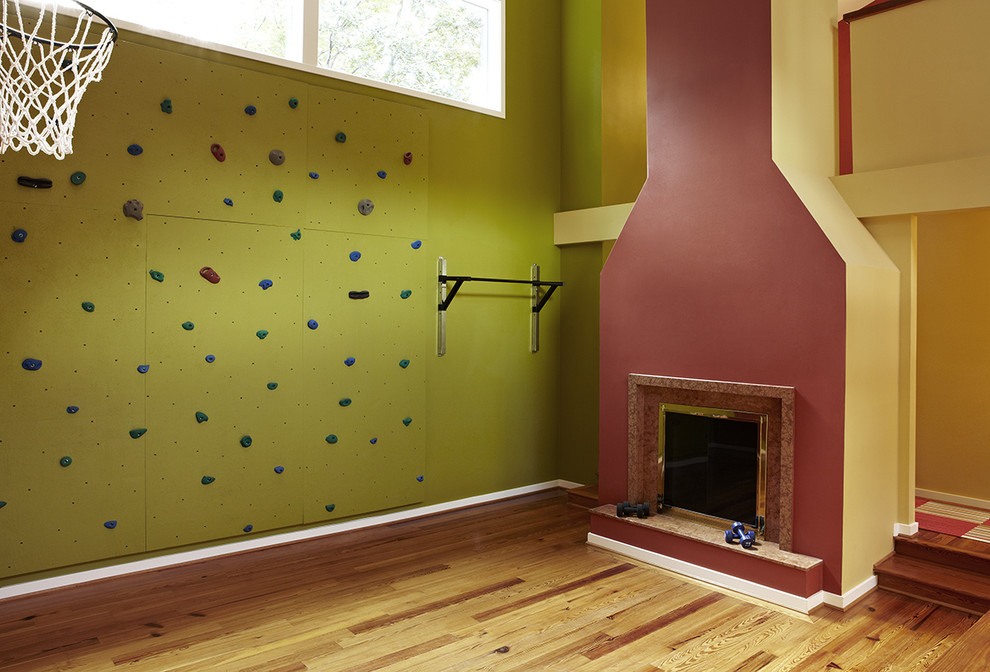Klassischer Fitnessraum mit Kletterwand, bunten Wänden, hellem Holzboden und braunem Boden in Washington, D.C.