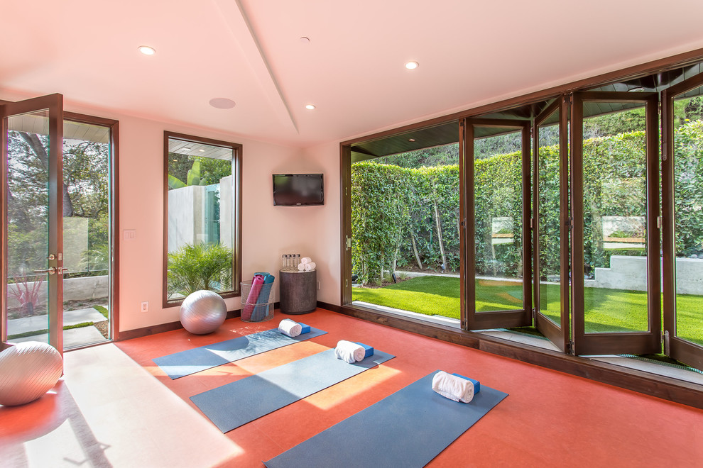 Exemple d'un studio de yoga tendance de taille moyenne avec un mur blanc et un sol rouge.