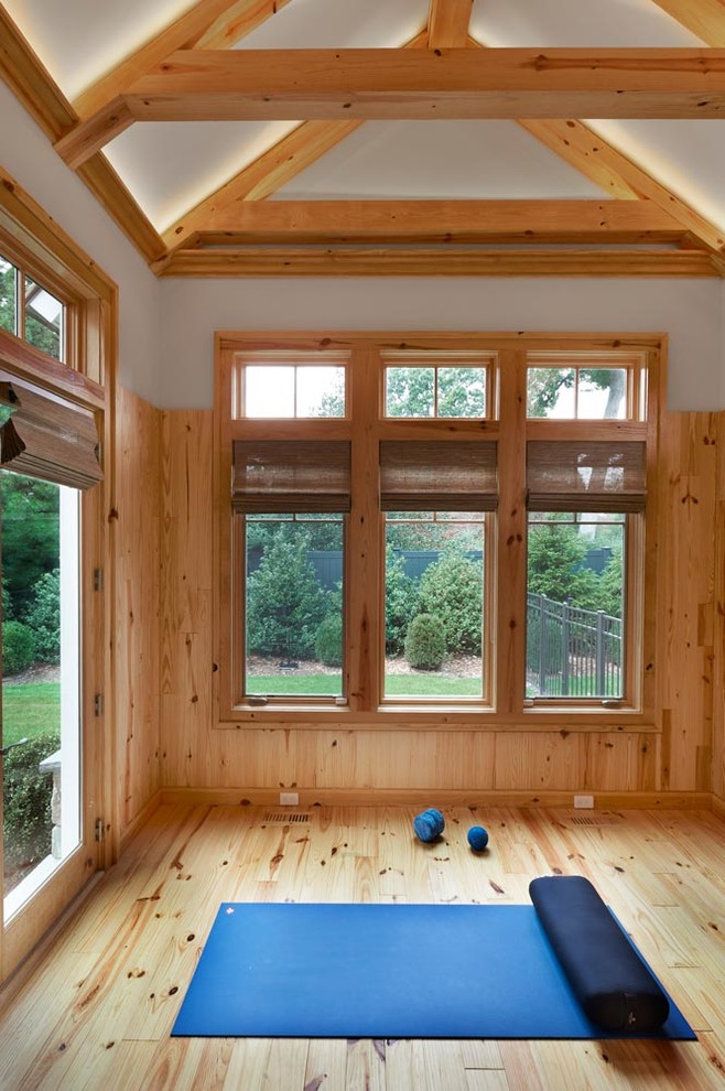 Diseño de estudio de yoga clásico renovado con suelo de madera en tonos medios