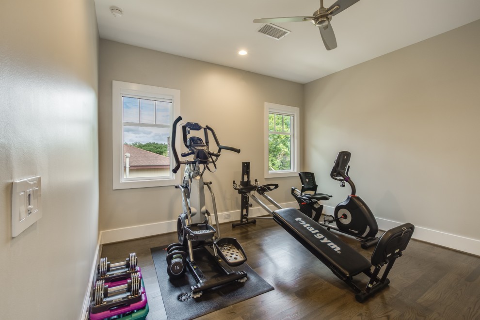 Example of a mid-sized mid-century modern medium tone wood floor and brown floor multiuse home gym design with beige walls