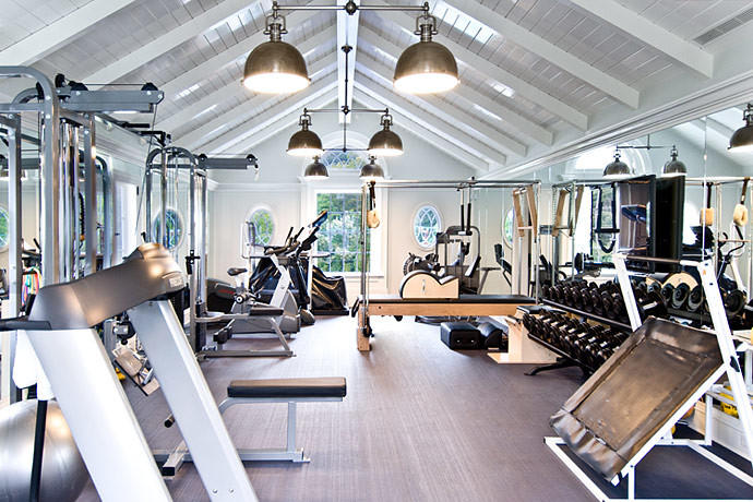 Expansive classic home weight room in Los Angeles with white walls and feature lighting.